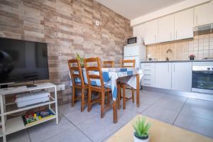 a kitchen with a table and chairs and a television at Edificio Prieto VIV 5 in Puerto del Rosario +30 photos