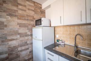 a kitchen with a white refrigerator and a sink at Edificio Prieto VIV 5 in Puerto del Rosario