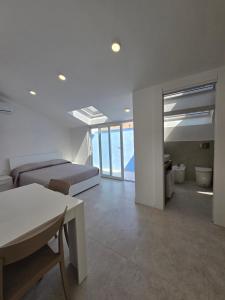 a white room with a bed and a couch and a table at Dimore Marche Porto Recanati in Porto Recanati +8 photos