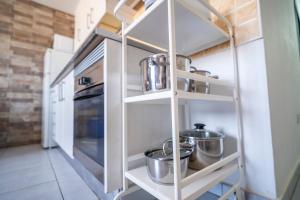 a kitchen with white shelves with pots and pans at Edificio Prieto VIV 5 in Puerto del Rosario