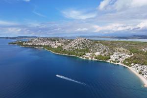 an island with a boat in a body of water at Ahoi House 7 Luxus Ferienhaus direkt am Meer mit Terrasse ideal für Familien in Drage