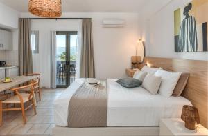a bedroom with a bed and a table and a kitchen at Arlen Beach Hotel in Hersonissos +47 photos