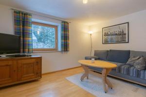a living room with a couch and a table at Haus Wörle- Ferienwohnung "Hahle" in Musau