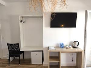 a room with a desk and a television on the wall at HOSTAL CASA EMILIO in Almería