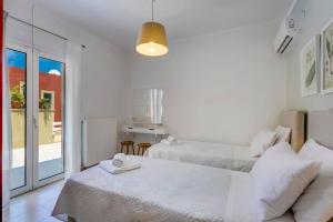 a white room with two beds and a kitchen at Villa Areva by Villa Plus in Panormos Rethymno +12 photos