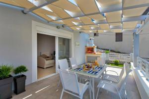 a dining room with a table and white chairs at Villa Areva by Villa Plus in Panormos Rethymno