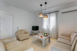 a living room with a couch and chairs and a table at Villa Areva by Villa Plus in Panormos Rethymno
