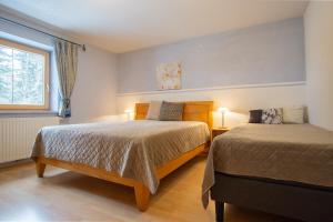 a bedroom with two beds and a window at Haus Wörle- Ferienwohnung "Hahle" in Musau