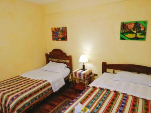 a bedroom with two beds and a table with a lamp at Hostal Restaurant TOROTORO in Torotoro +36 photos