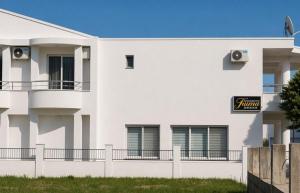 a white building with a sign on the side of it at Long Beach Truma in Ulcinj +16 photos