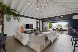 a living room with a couch and a tv at Villa lEscale de Sainte Philomène in Saint-Pierre