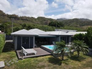 a house with a deck and a swimming pool at Villa lEscale de Sainte Philomène in Saint-Pierre
