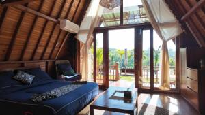 a living room with a blue bed and a table at Cascadia Rad Villa in Jatiluwih +81 photos