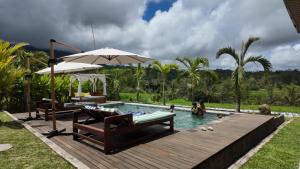 a swimming pool with a deck and an umbrella at Cascadia Rad Villa in Jatiluwih