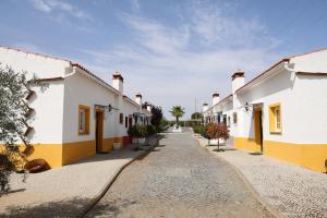 a cobblestone street with white and yellow buildings at Olívale - Turismo Rural in Campo Maior