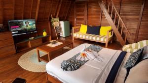 a living room with a couch and a tv at Cascadia Rad Villa in Jatiluwih
