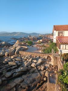 a view of a rocky shore with houses and the ocean at Departamentos Océano in Maitencillo