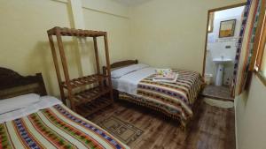 a small bedroom with two beds and a sink at Hostal Restaurant TOROTORO in Torotoro