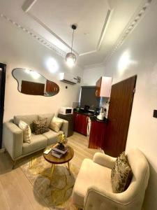 a living room with two couches and a table at Nimble Focus Apartment in Lagos