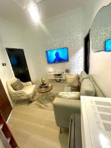 a living room with a couch and a tv at Nimble Focus Apartment in Lagos