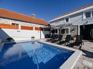 a swimming pool in front of a house at La Felicita in Gornji Zemunik