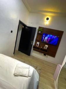 a bedroom with a bed and a flat screen tv at Nimble Focus Apartment in Lagos
