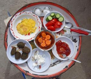 a tray of food with plates and bowls of food at Sun Rise House Luxor in Al Aqālitah