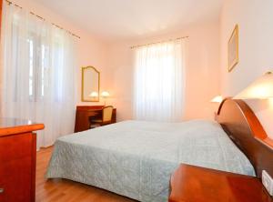a bedroom with a bed and a desk and a window at Villa Nature Retreat in Gruda
