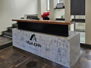 ein Empfangstresen in einer Lobby mit einem Aidium-Schild in der Unterkunft Villajohn in Ad Dā‘ūq