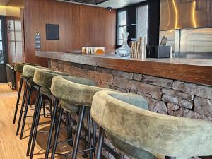 eine Bar mit einer Reihe von Barhockern in einem Restaurant in der Unterkunft Villajohn in Ad Dā‘ūq