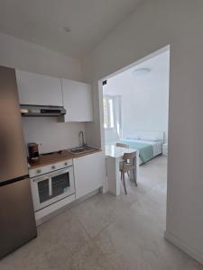 a kitchen with a stove and a table and a bed at Dimore Marche Porto Recanati in Porto Recanati