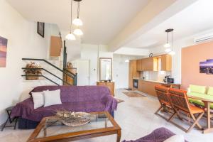 a living room with a purple couch and a table at Serene Villa in Kriopigi
