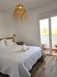 a bedroom with a white bed and a large window at HOSTAL CASA EMILIO in Almería