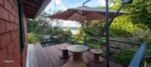 a wooden deck with a table and an umbrella at Cabaña Alto Verde in Chiquinquirá