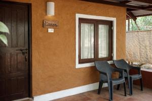 a room with three chairs and a door at Nature's Nest Goa in Molem