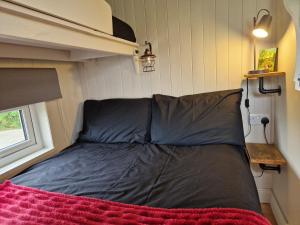 a bed in the corner of a tiny house at Bramblewick House Glamping in Longford