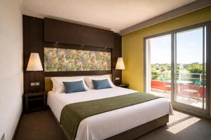 a bedroom with a large bed and a large window at Le Safari Hotel Restaurant in Carpentras +49 photos