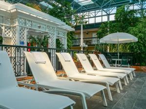 a row of white lounge chairs in a building at Best Western Plus Cairn Croft Hotel in Niagara Falls