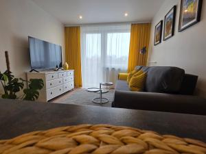 a living room with a couch and a television at Perełka Południa in Głuchołazy +2 photos