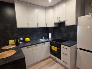 a kitchen with white cabinets and a sink at Perełka Południa in Głuchołazy