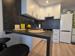 a kitchen with a black counter and white cabinets at Perełka Południa in Głuchołazy