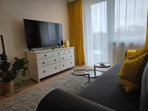 a living room with a couch and a television on a dresser at Perełka Południa in Głuchołazy