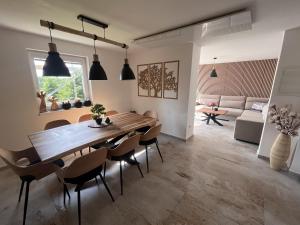a dining room and living room with a wooden table and chairs at Chata pod loukou in Tvarožná Lhota