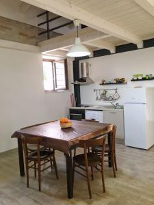 eine Küche mit einem Holztisch und Stühlen in der Unterkunft Casa Vacanza Piazza Gramsci 1 in Scanzano
