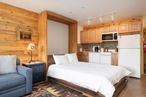 a bedroom with a white bed and a blue chair at 564 Silvercreek Inn in Granby
