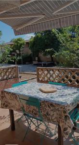 a table and two chairs sitting under an umbrella at La maison papillons in Quissac