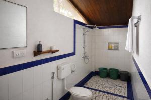 a bathroom with a toilet and two green buckets at Nature's Nest Goa in Molem +67 photos