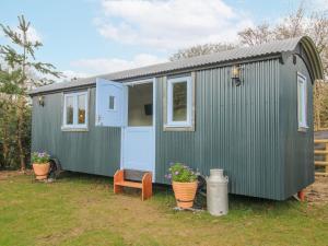 a green tiny house sitting in a yard at Skye in Ludlow