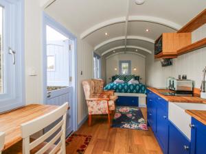 a kitchen with blue cabinets and a bed in a room at Skye in Ludlow +11 photos