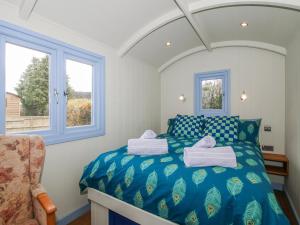 a bedroom with a blue bed with towels on it at Skye in Ludlow